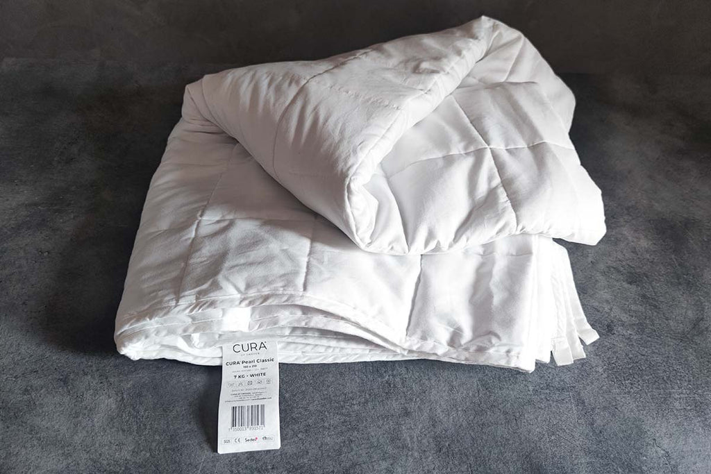 CURA Pearl Classic weighted duvet folded with product label