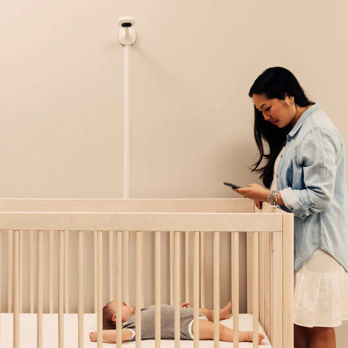 Nanit Pro wall-mounted baby monitor above crib